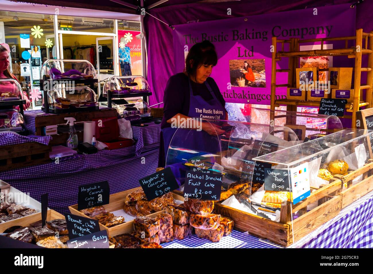 Woman from the Rustic Baking Company selling fancy chocolate flapjacks  on a stall at the weekly Market  Redcar High Street Cleveland England UK Stock Photo