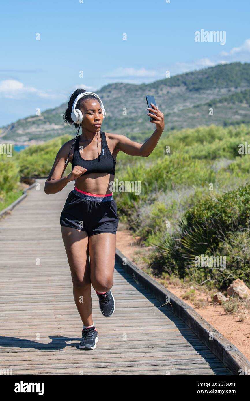 Running afro american woman with headphones taking a photo of herself Stock  Photo - Alamy