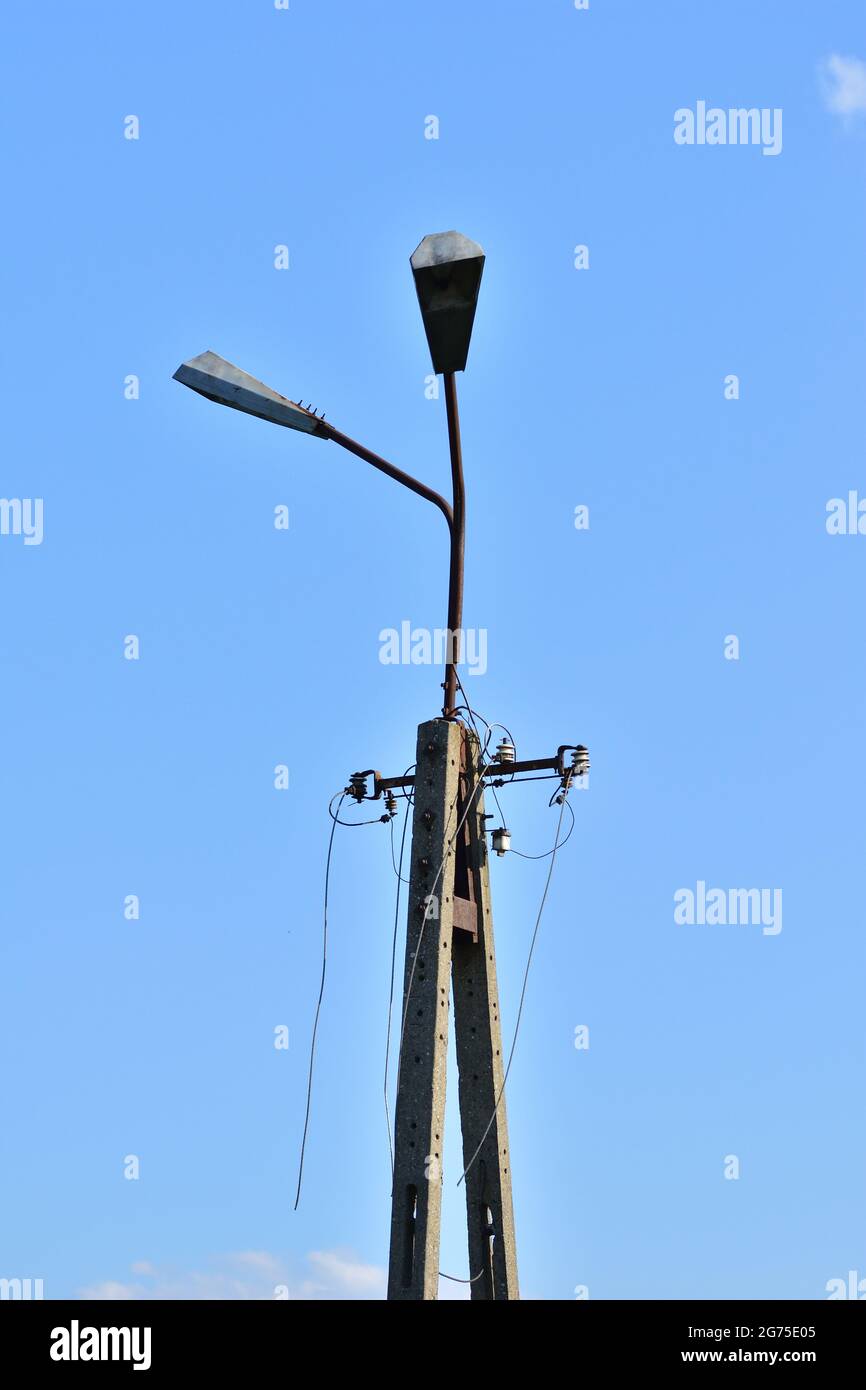 Broken electric wires on the pole and on the lamp. Summer. Stock Photo
