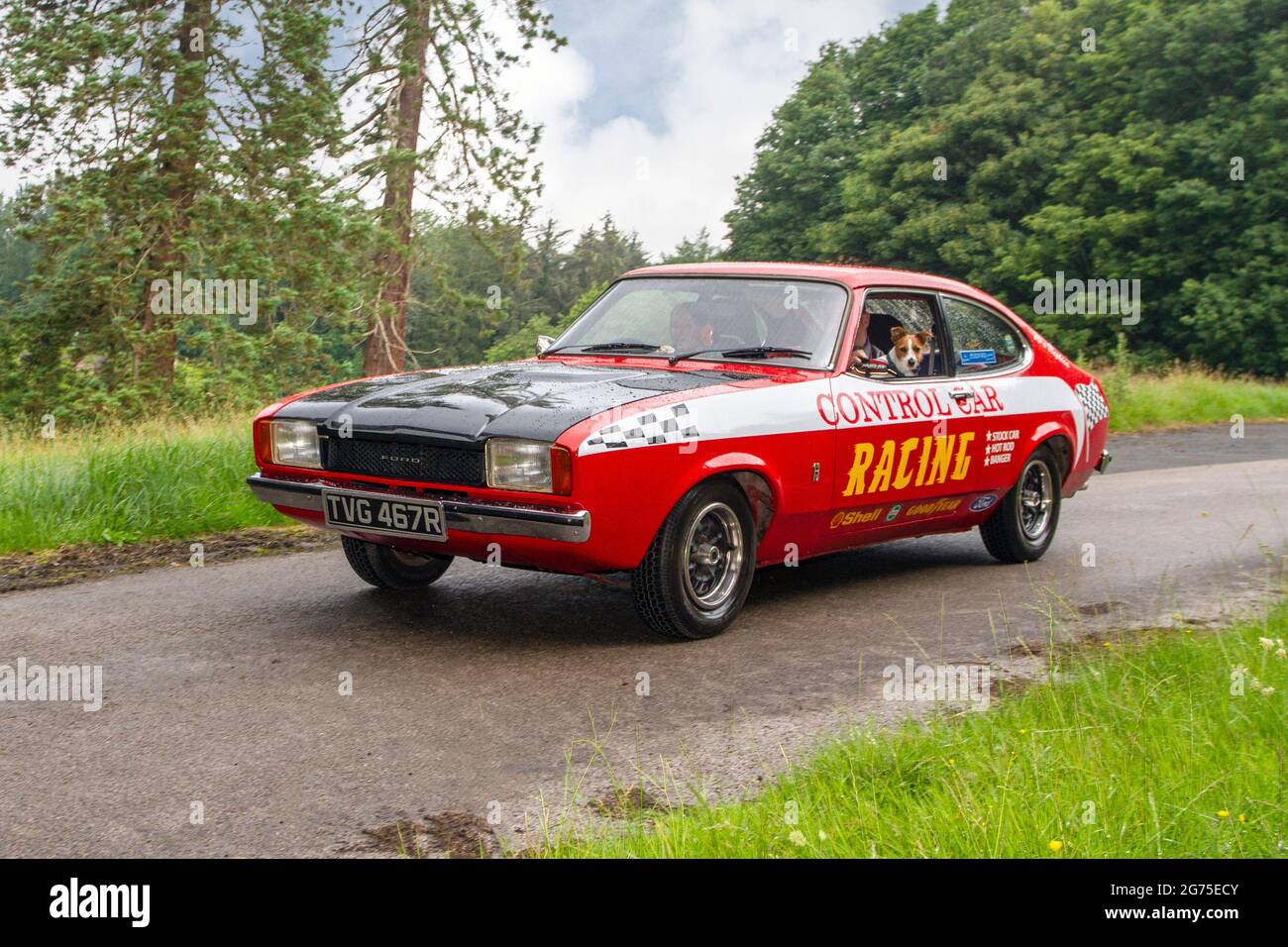 1977 70s red white Ford Capri 1298cc petrol coupe, Control car racing en-route KLMC The Cars The Star Show in Holker Hall & Gardens, Grange-over-Sands, UK Stock Photo