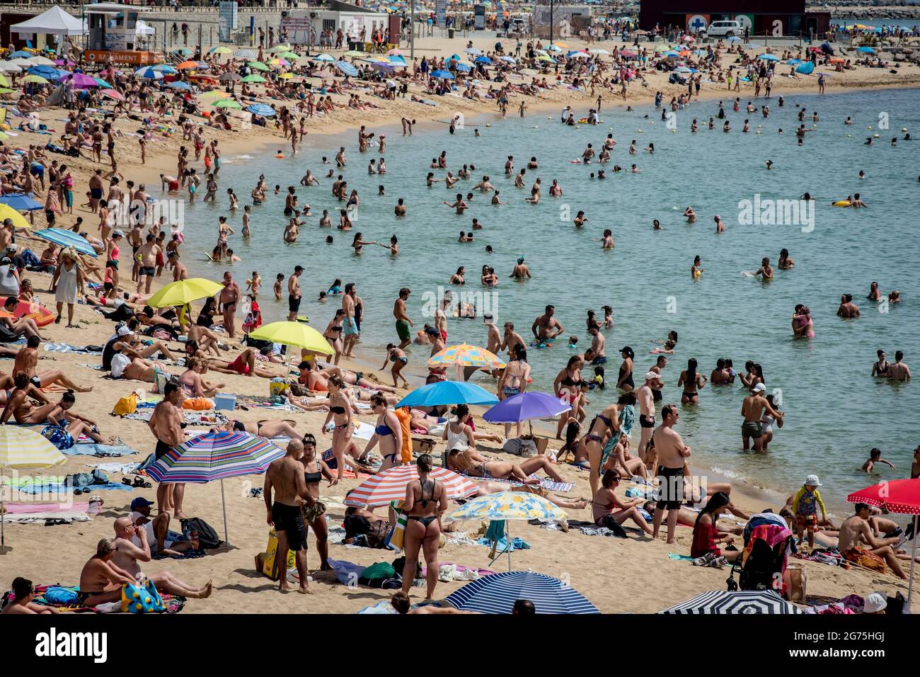 On this July sunday people crowds and cool off at Nova Icaria beach in Barcelona amid the COVID-19 Delta variant surge and a heat wave affecting the Iberian Peninsula. Stock Photo