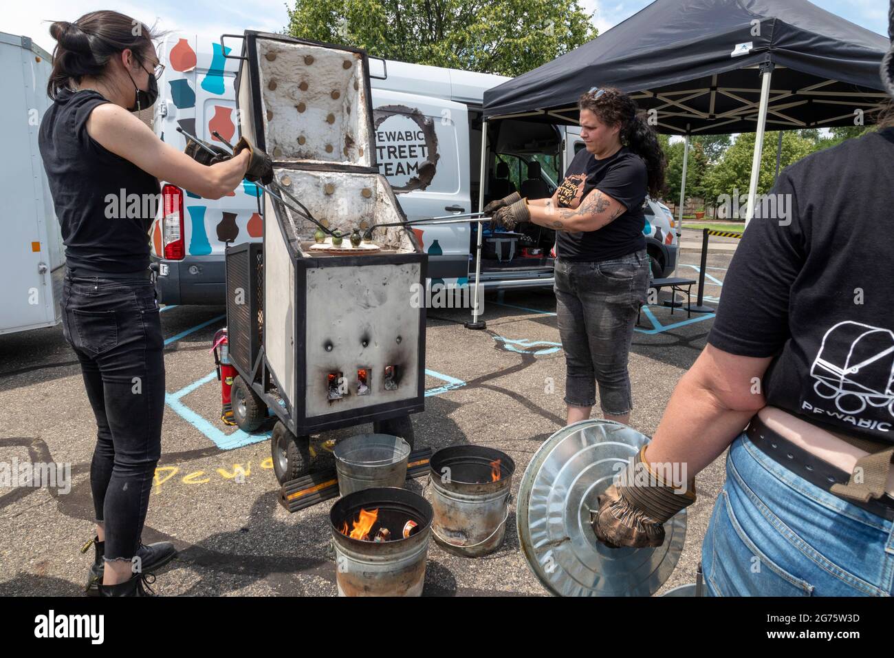 Detroit, Michigan - Members of the Pewabic Pottery Street Team demonstrate the Japanese technique of Raku Firing of pottery at a community arts and mu Stock Photo