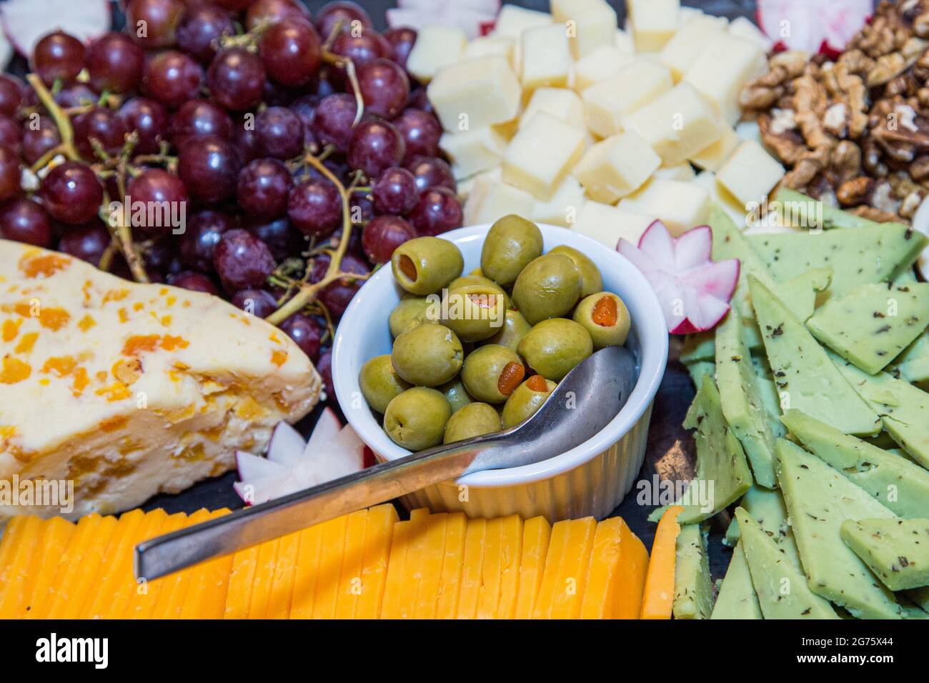 An arrangement of fruit and cheese on a platter Stock Photo