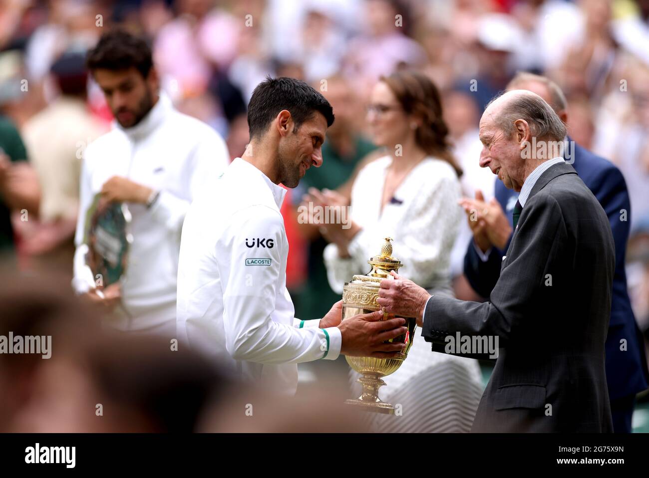 The Duke of Kent (right) presents Novak Djokovic with his trophy after winning the Gentlemen's Singles Final against Matteo Berrettini on centre court on day thirteen of Wimbledon at The All England Lawn Tennis and Croquet Club, Wimbledon. Picture date: Sunday July 11, 2021. Stock Photo