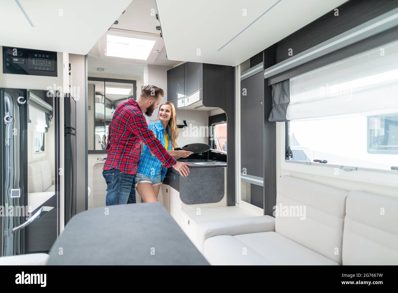 Woman and man testing interior of camper they want to buy or rent Stock Photo