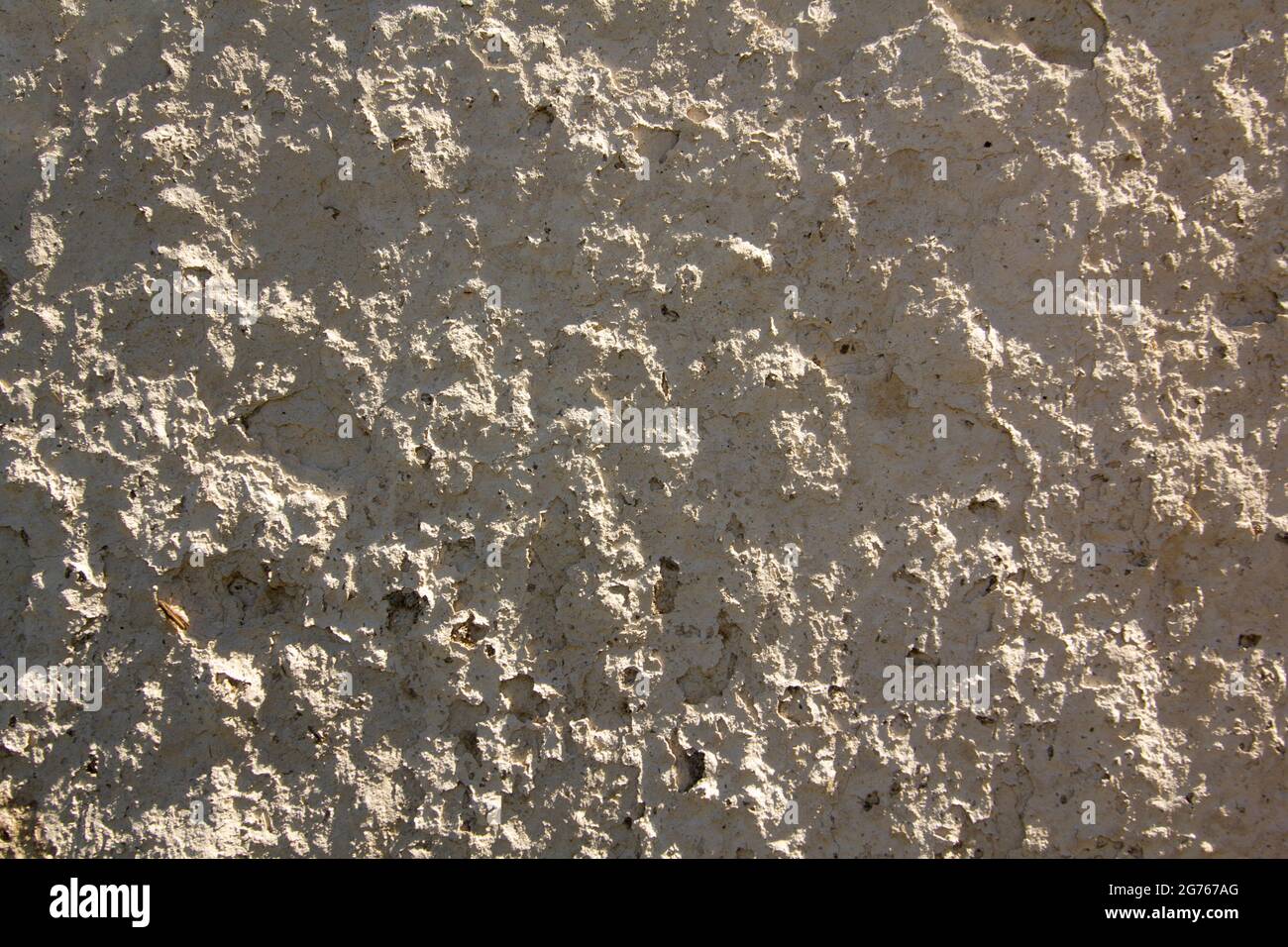 Background looks like a bright rough rustic plaster with rigid natural solar lighting at noon. Stock Photo