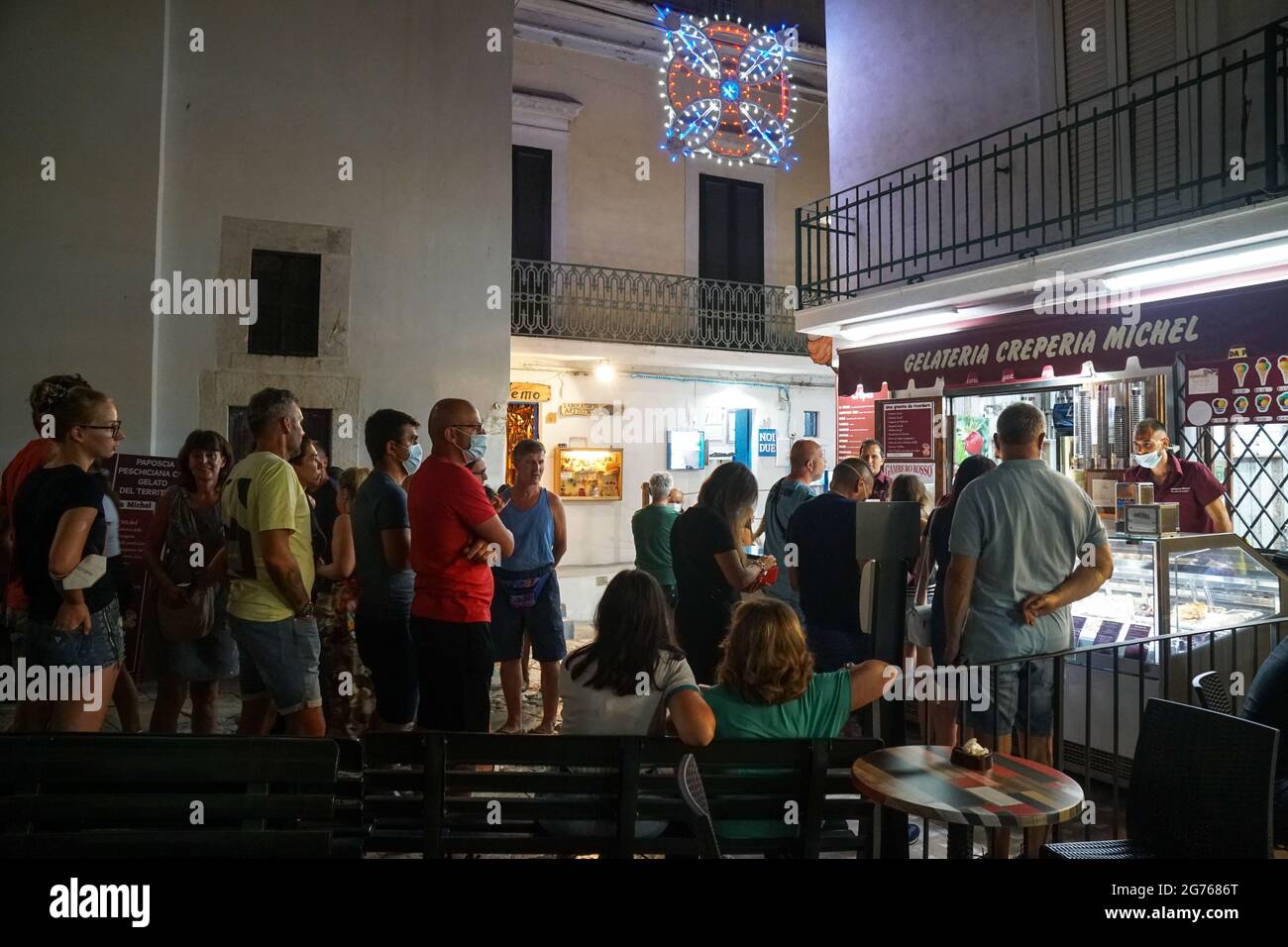 Peschici - 29/06/2021: famous italian ice cream shop with people in Peschici at night , Puglia, Italy Stock Photo