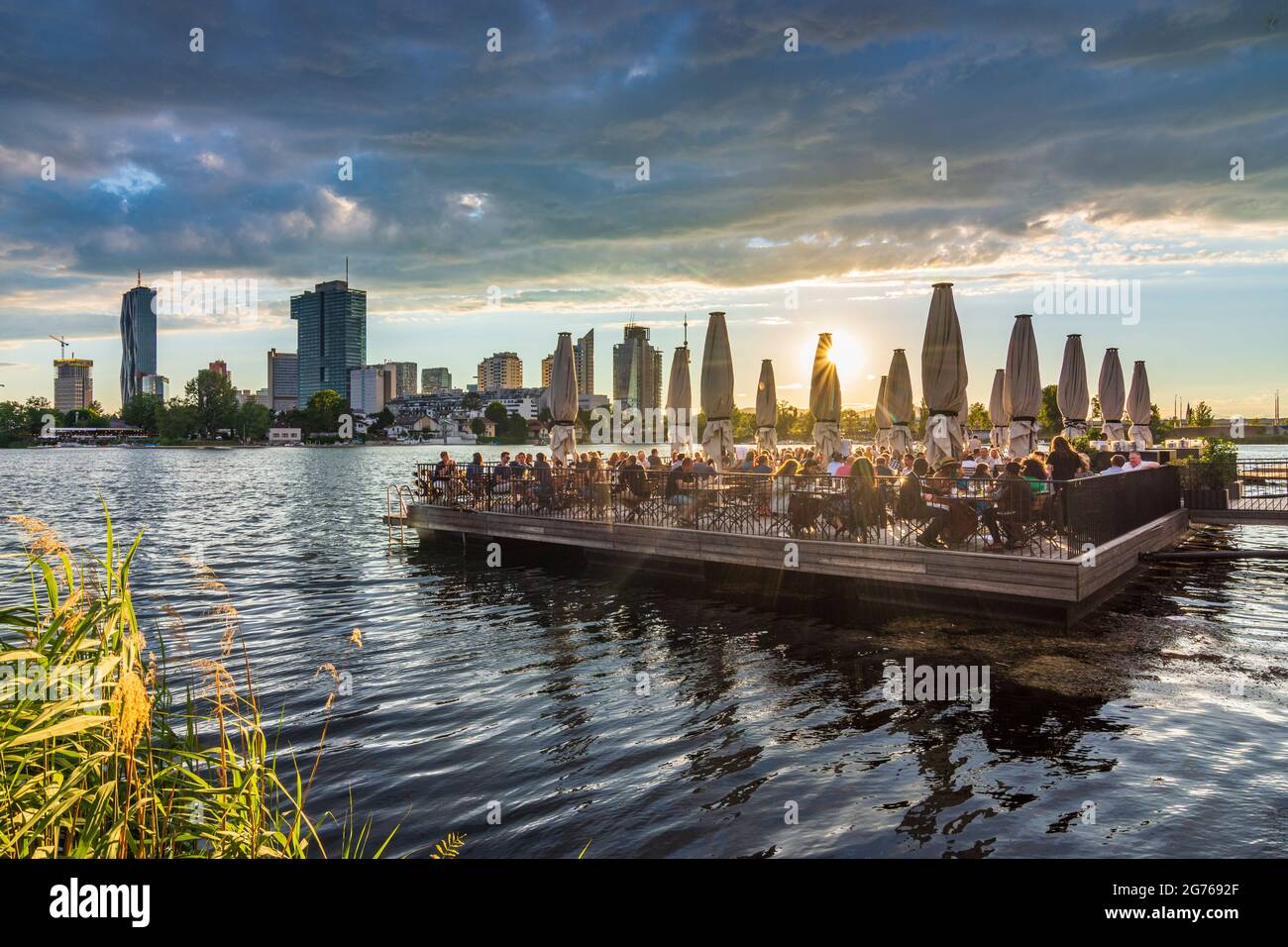 Wien, Vienna: late sun at river Alte Donau (Old Danube), floating platform  of restaurant Strandcafe, boats, tower Donauturm, highrises of Donaucity, D  Stock Photo - Alamy