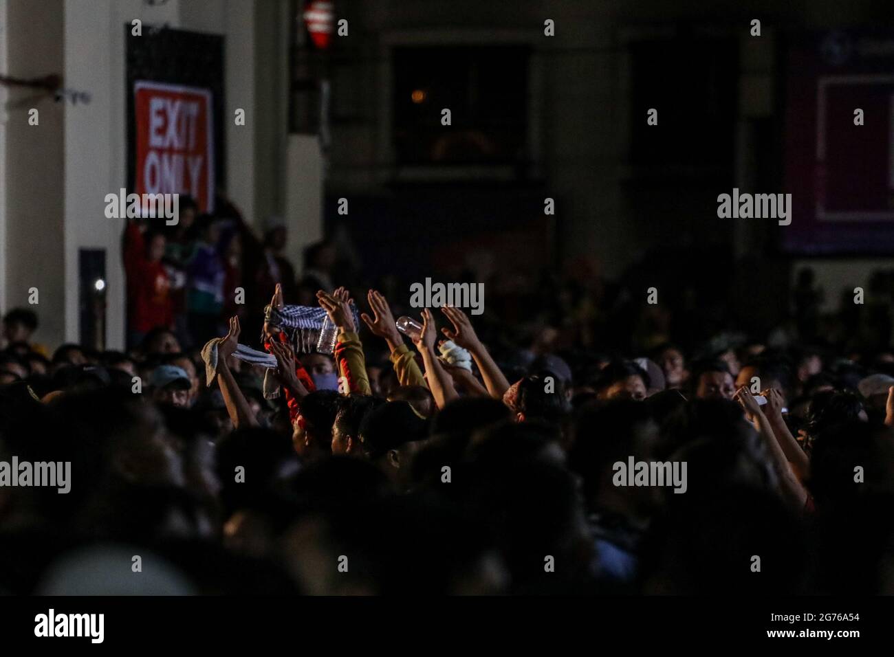 Filipino Catholic devotees raise miniature replicas of the Black Nazarene in Manila. A mammoth crowd of mostly barefoot Filipino Catholics prayed for peace in the increasingly volatile Middle East at the start of an annual procession of a centuries-old black statue of Jesus Christ in one of Asia's biggest religious events. Philippines. Stock Photo