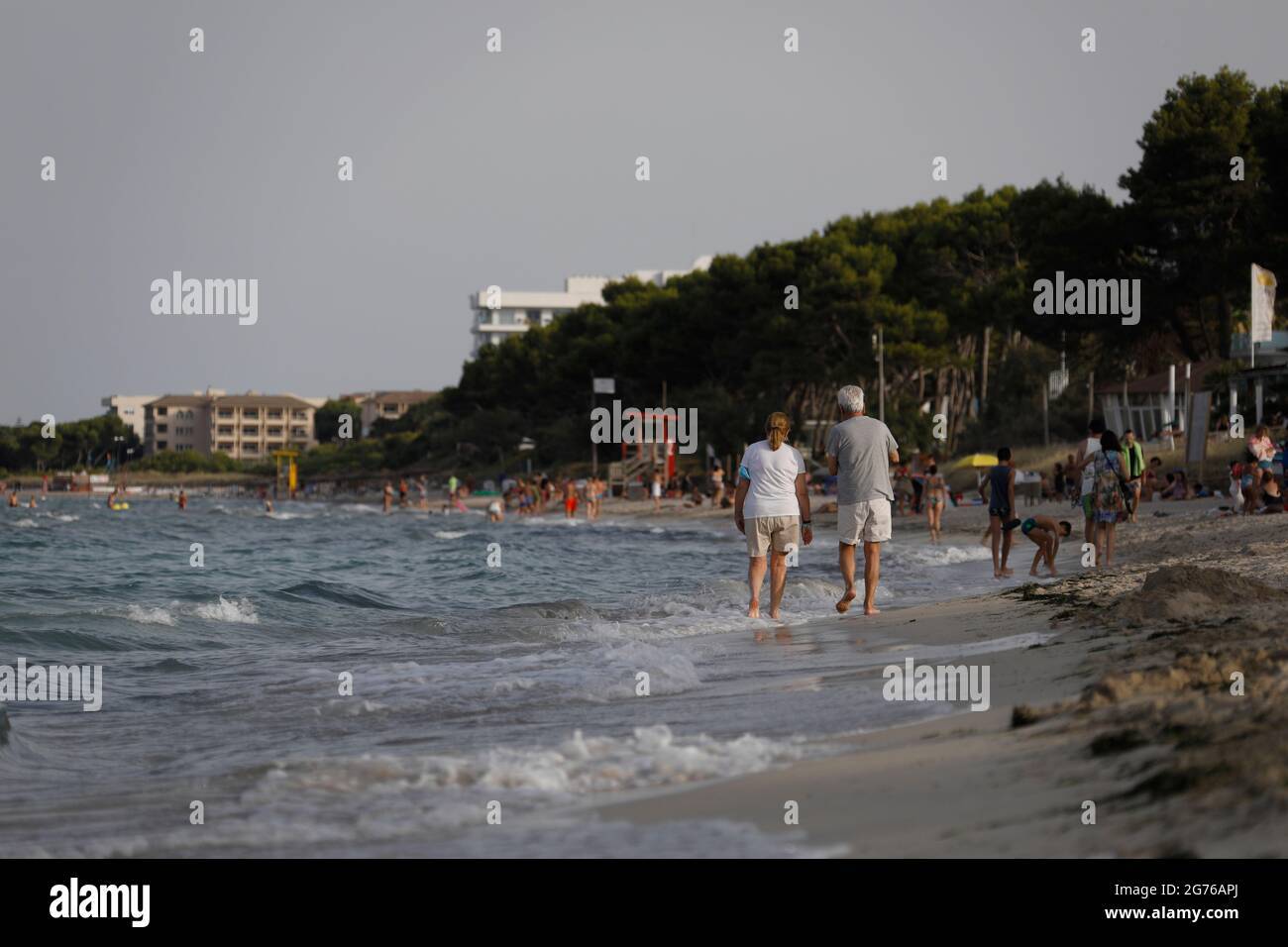 Spain. 11th July, 2021. People enjoy the sea at the beach Playa de Muro in the north of Mallorca. The federal government has declared all of Spain with Mallorca and the Canary Islands in view of rapidly increasing Corona numbers to the risk area. The practical effects for Mallorca holidaymakers are limited for the time being. Credit: Clara Margais/dpa/Alamy Live News Stock Photo