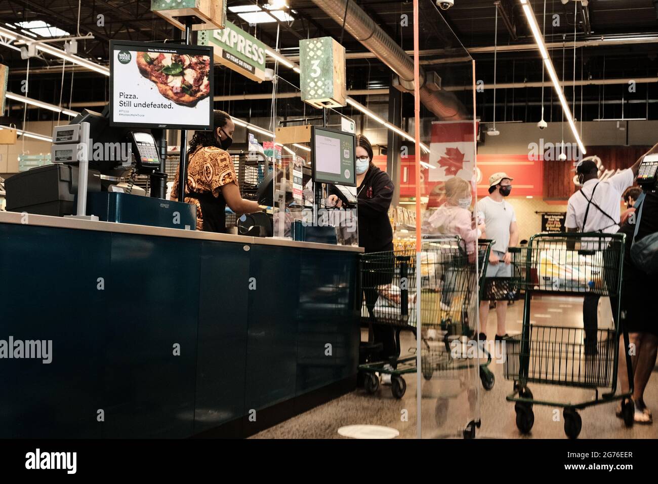 Cashier and customers at the checkouts at the Whole Foods Market, Lansdowne, Ottawa, Ontario, Canada. Stock Photo