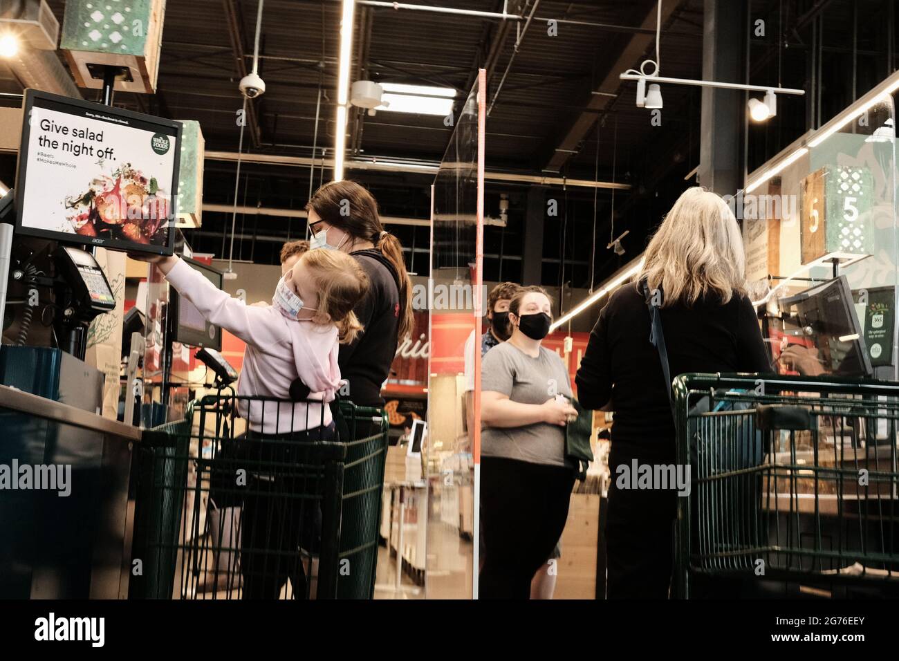 Customers lining up at the checkouts (separated by a plexiglass screen