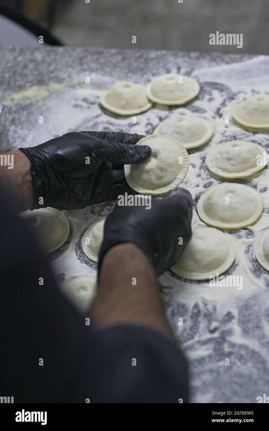 A closeup of male hands wearing black gloves making fresh circular ...