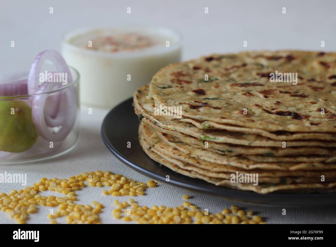 A high protein Indian flat bread with whole wheat and lentils. Popularly known as moong dal paratha in many parts of India. Shot on white background. Stock Photo