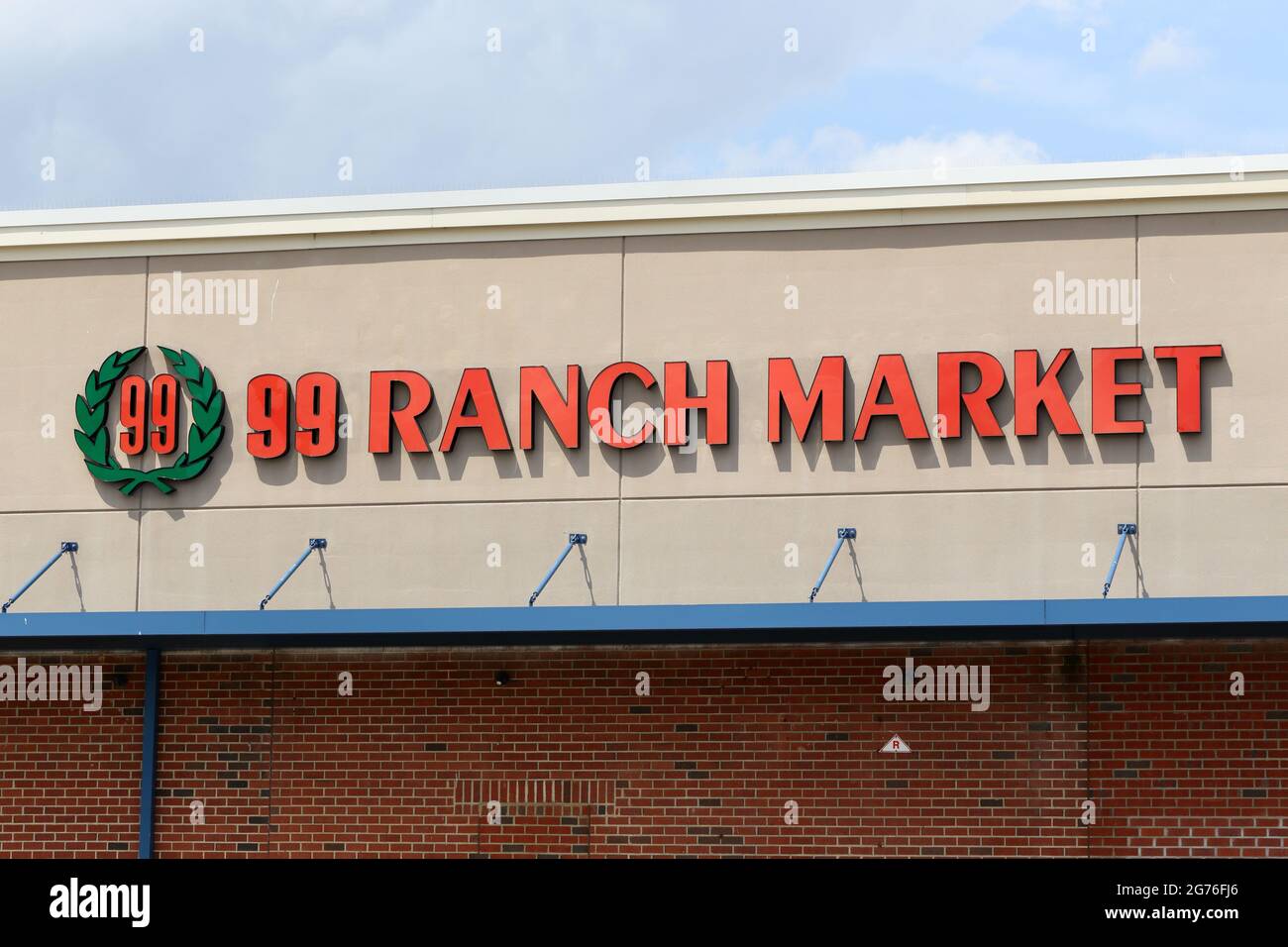 Signage for 99 Ranch Market brightly lit against a wall. Stock Photo