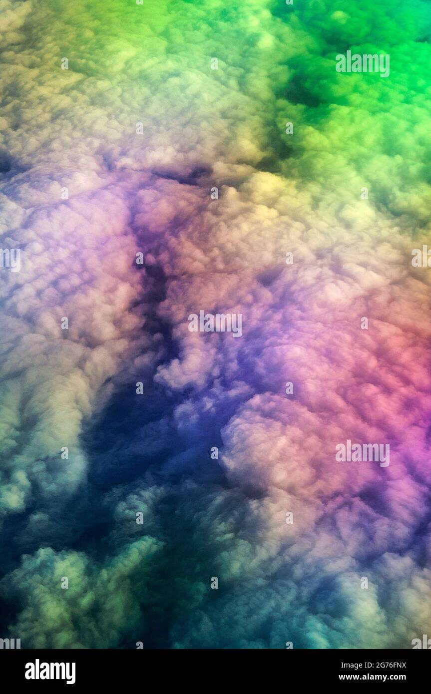 Aerial, flying over dense clouds at 35000 feet, refracted light, photographed from the window seat in a regular, commercial flight. Cloudscape. Stock Photo