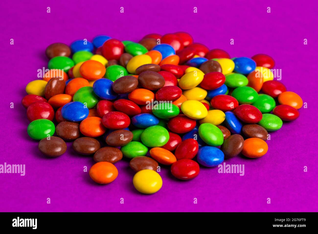 A Pile of Rainbow Colored Candy Coated Chocolate Buttons Stock Photo