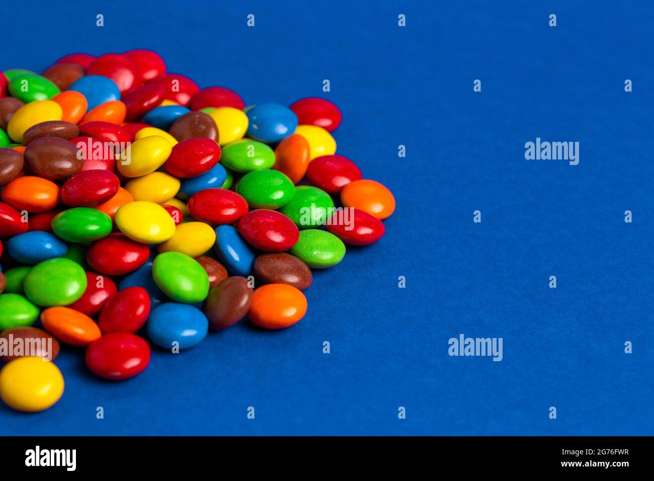 A Pile of Rainbow Colored Candy Coated Chocolate Buttons Stock Photo
