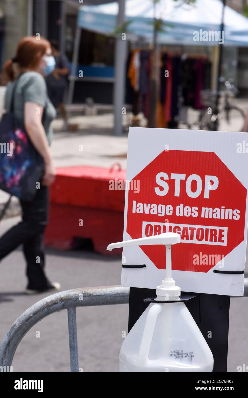 Mandatory request to disinfect hands before entering sidewalk sale, Montreal Canada / Covid-19 Pandemic Stock Photo