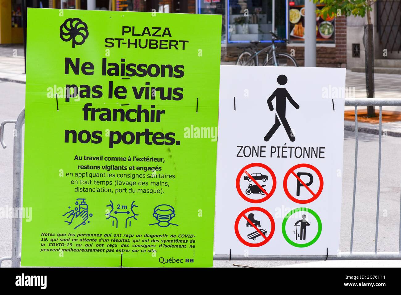 Public Notice at sidewalk sale: The sign warns people to be careful and respect sanitary measures in order not to catch Covid-19, Montreal, Canada Stock Photo