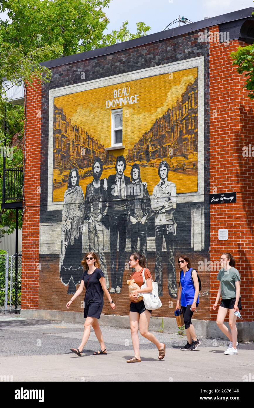 Young people walking in front of a Beau Dommage murale in the Petite Patrie Neighbourhood of