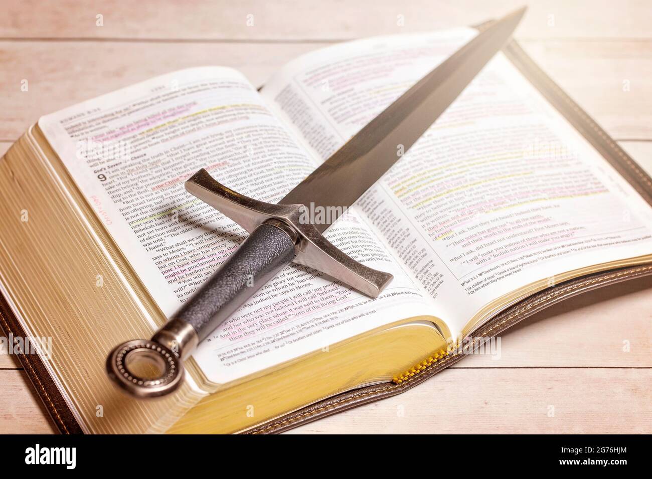 A Bible with a Sword on a Bright White Wooden Table Stock Photo Alamy