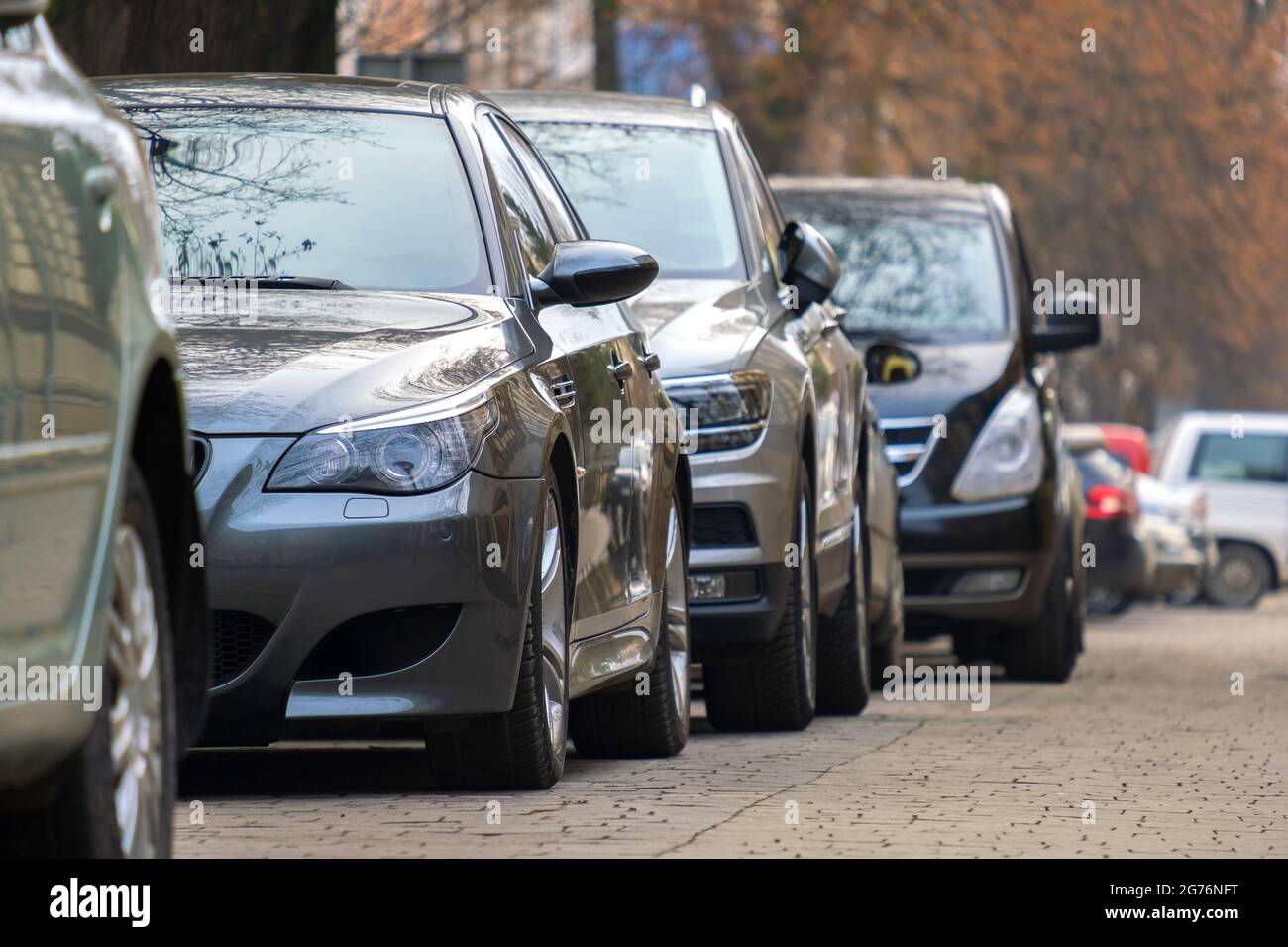 Cars parked in a row on a city street side Stock Photo - Alamy
