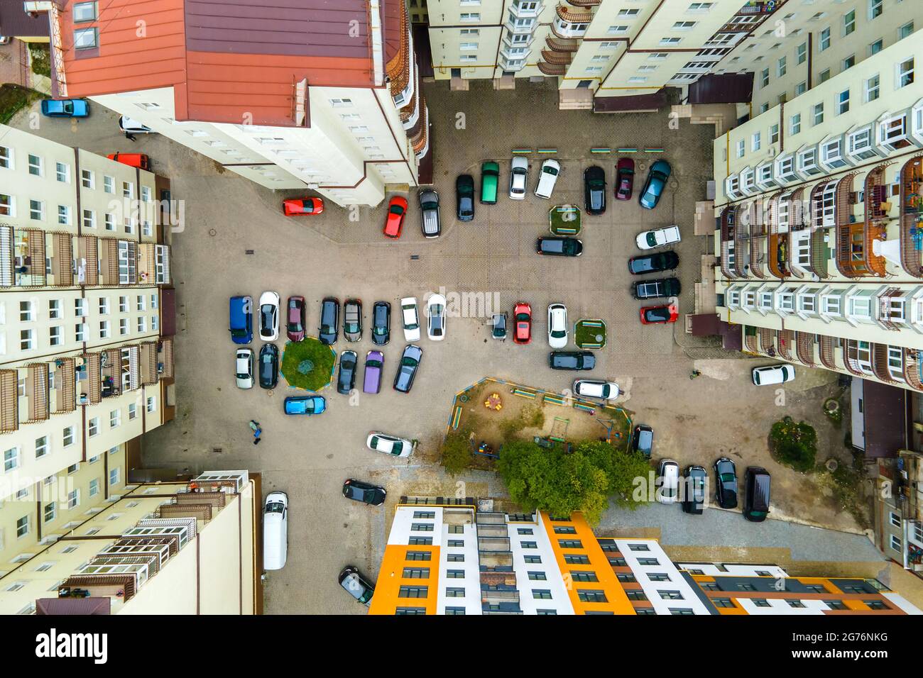 Aerial view of parked cars on parking lot between high apartment ...