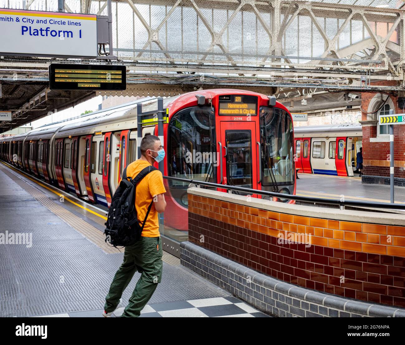 Man with rucksack on Platform 1 at Hammersmith Underground station on
