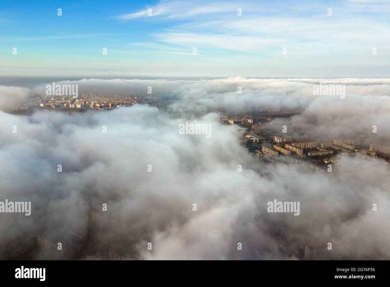 Top aerial view of fluffy white clouds over modern city with high rise ...