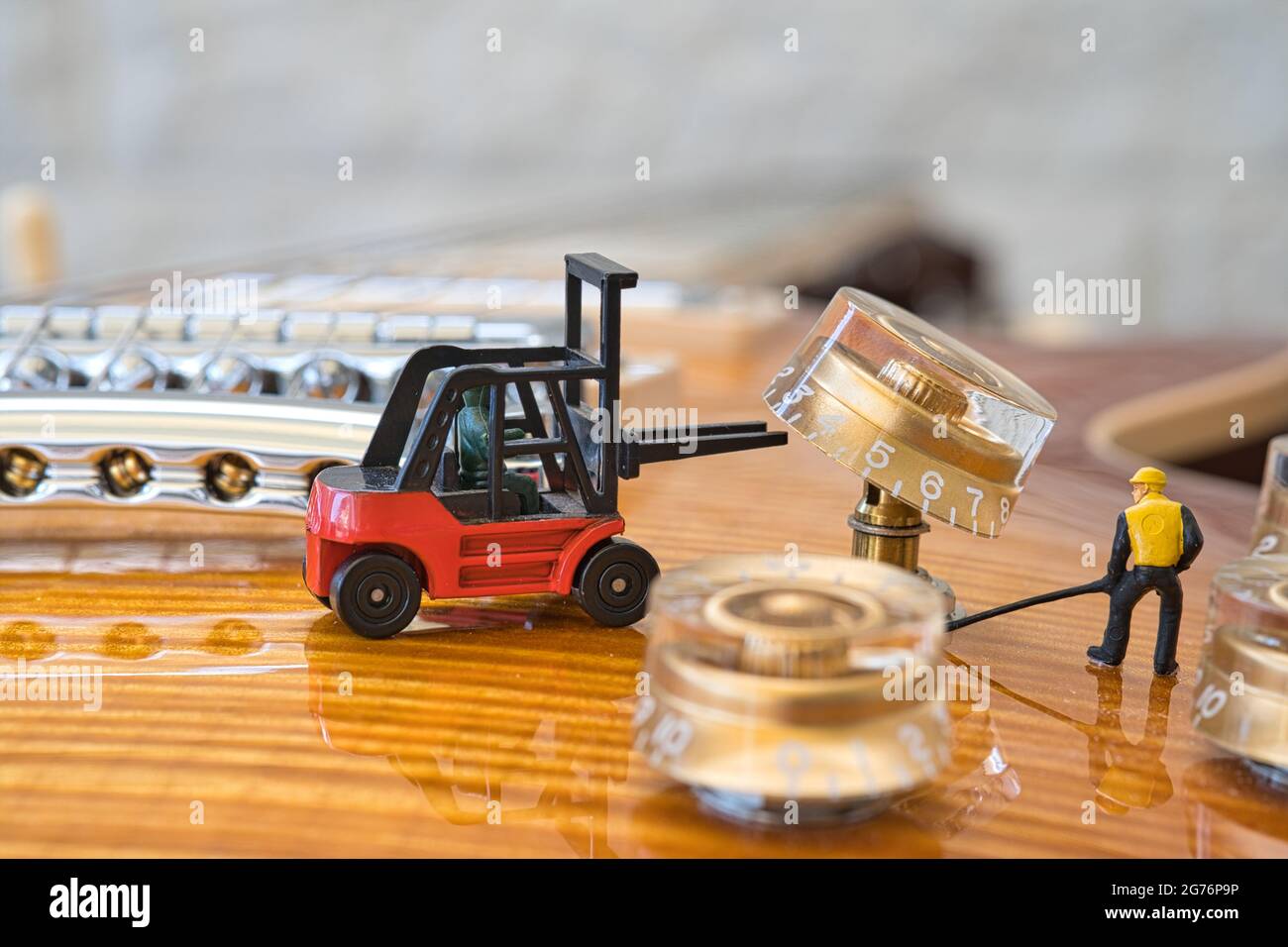 The miniature figures workers dismantle a rotary knob with a forklift