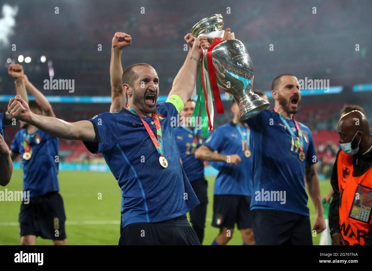 Italy's Giorgio Chiellini and Leonardo Bonucci carry the trophy and ...