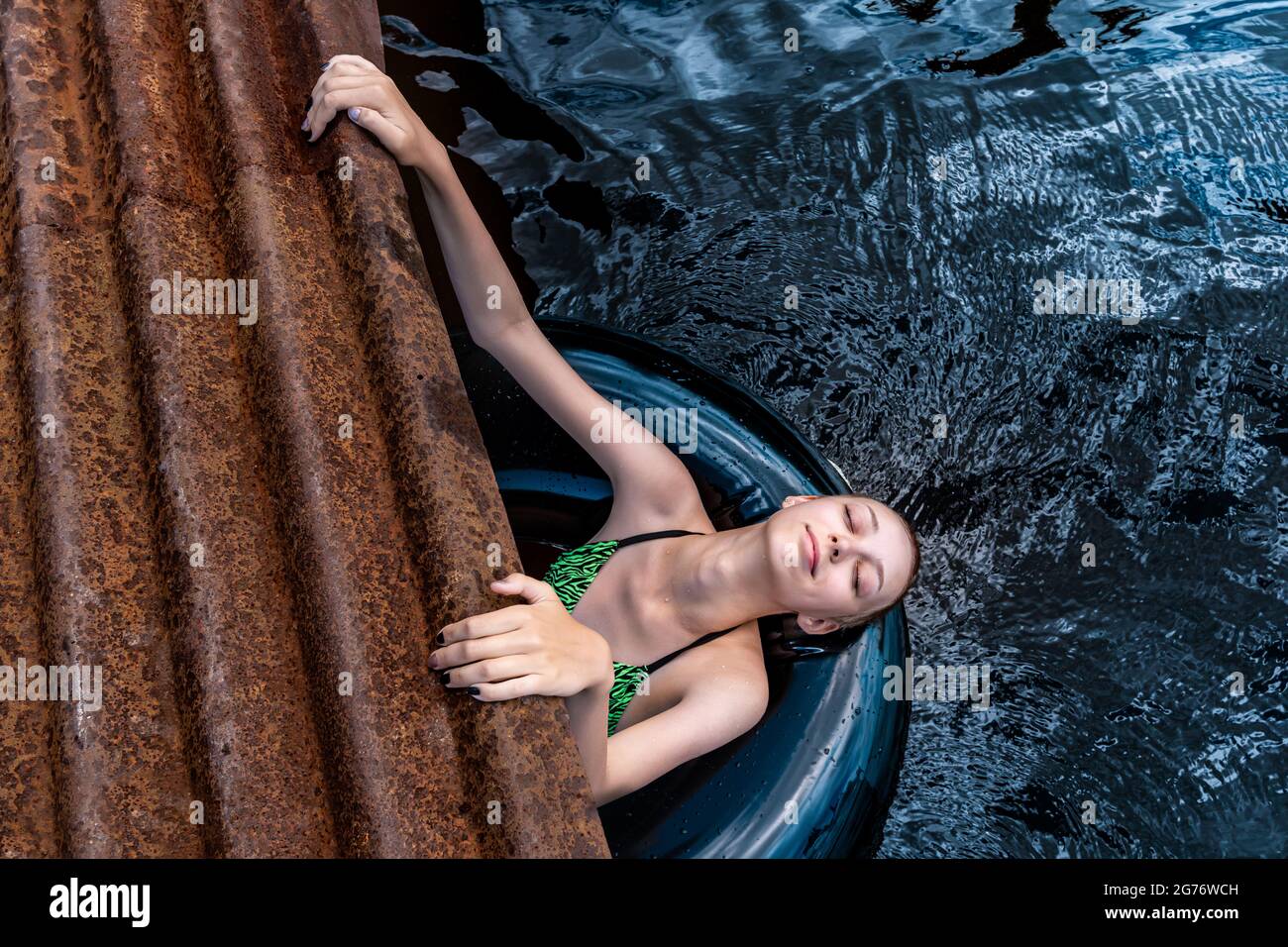 happy teen girl playing in the water using a swim tube Stock Photo