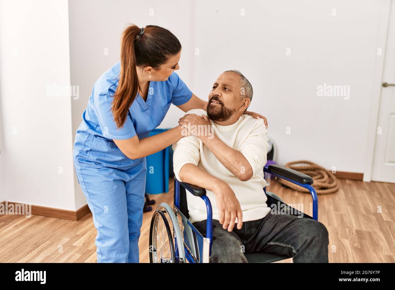 Senior man sitting on wheelchair and geriatric nurse at rehabilitation