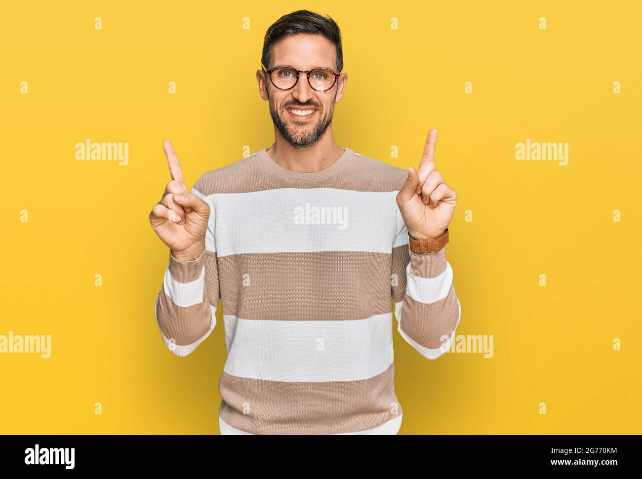 Handsome man with beard wearing casual clothes and glasses smiling confident pointing with fingers to different directions. copy space for advertiseme Stock Photo