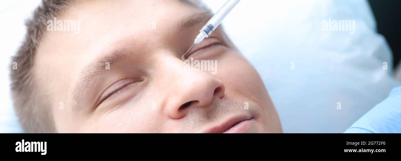 Man is given rejuvenating injection in his face Stock Photo