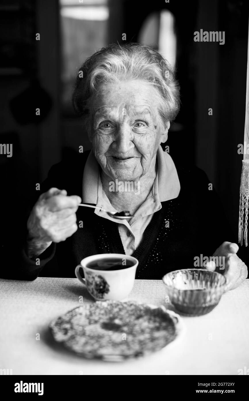 An elderly woman drinking tea. Black and white portrait Stock Photo Alamy