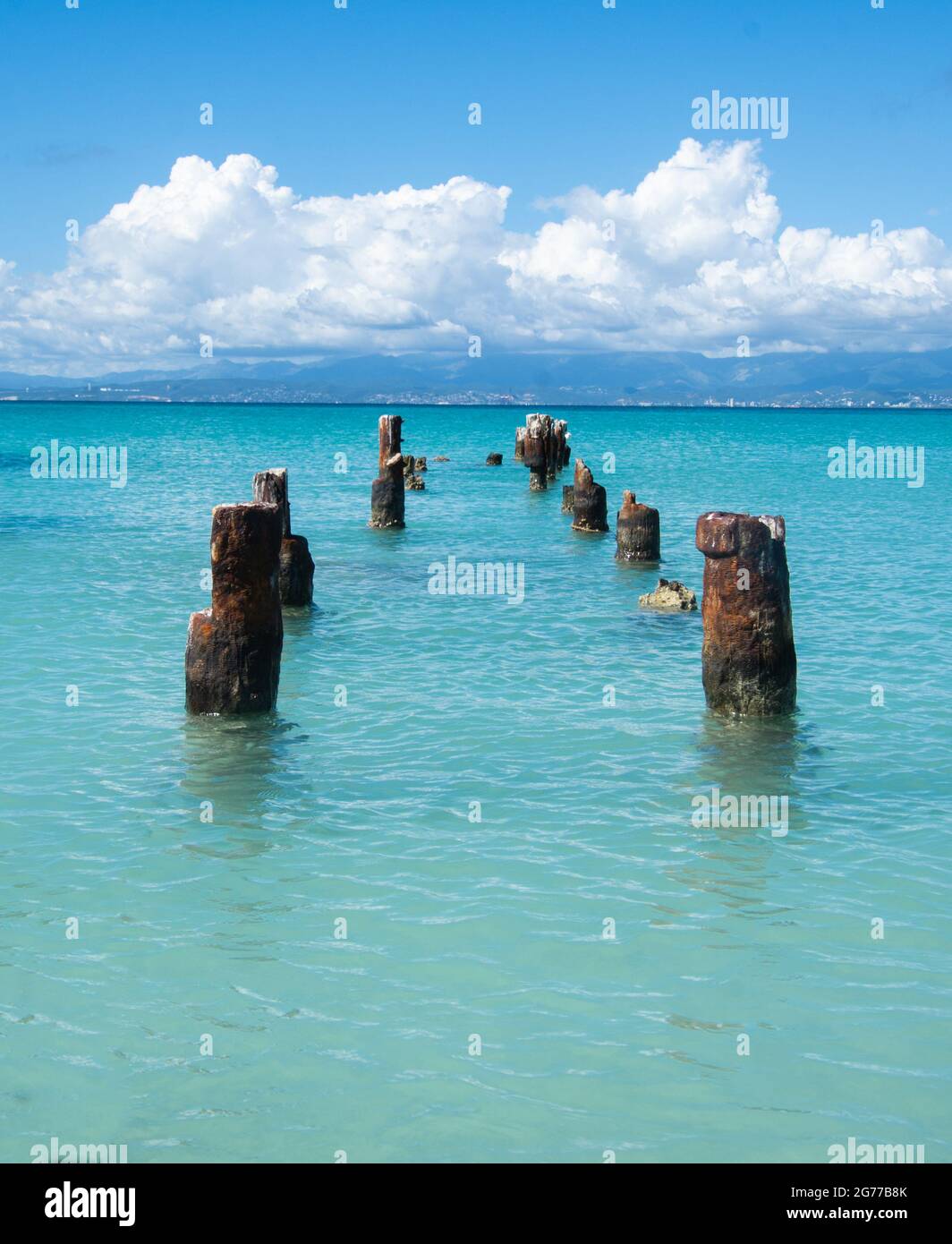 Old dock pilings in the turquoise water of the Caribbean Sea off the Isla de Cajos de Muertos, Puerto Rico, USA. Copy space. Stock Photo