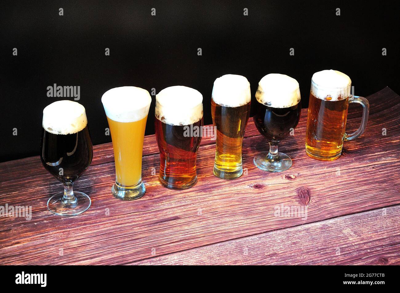 Three different beer glasses, with different types of beer, are in a