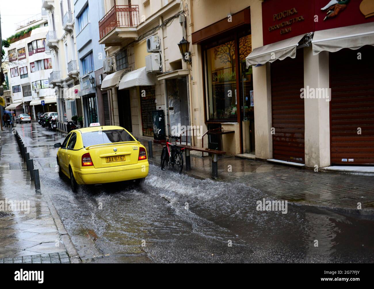 A taxi driving through a flooded street in Athengs, Greece. Stock Photo