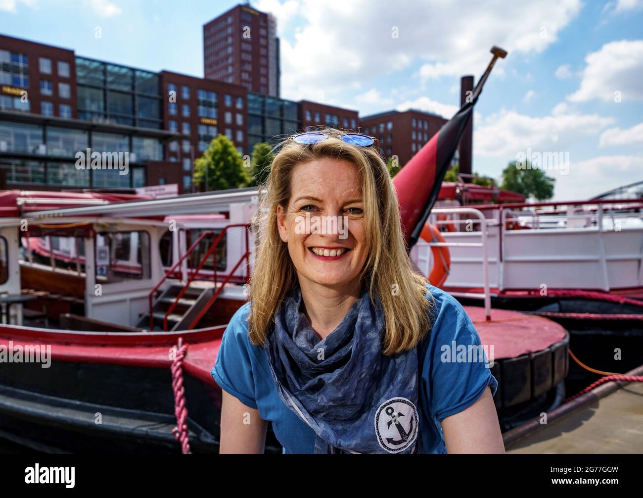 Hamburg, Germany. 25th June, 2021. Tour guide Maike Brunk sits in front of a launch before a tour of the Port of Hamburg. Brunk shows passengers hidden corners of the city on her tours. (to dpa KORR.: "Sehnsuchtsort Hafen: Tour guide Maike Brunk shows hidden corners") Credit: Axel Heimken/dpa/Alamy Live News Stock Photo