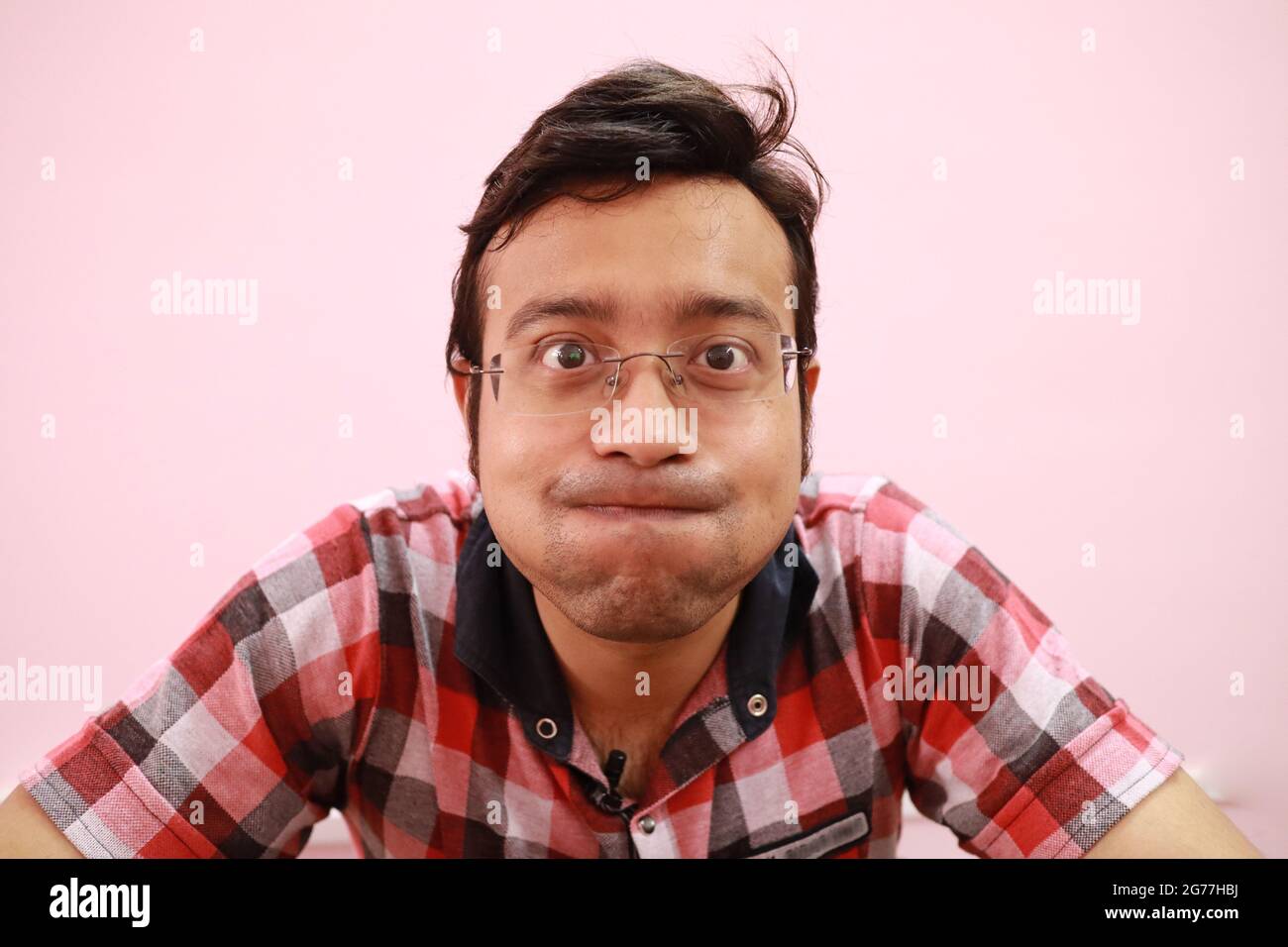 Funny Indian man suppressing his laughter isolated on a pink background  Stock Photo - Alamy