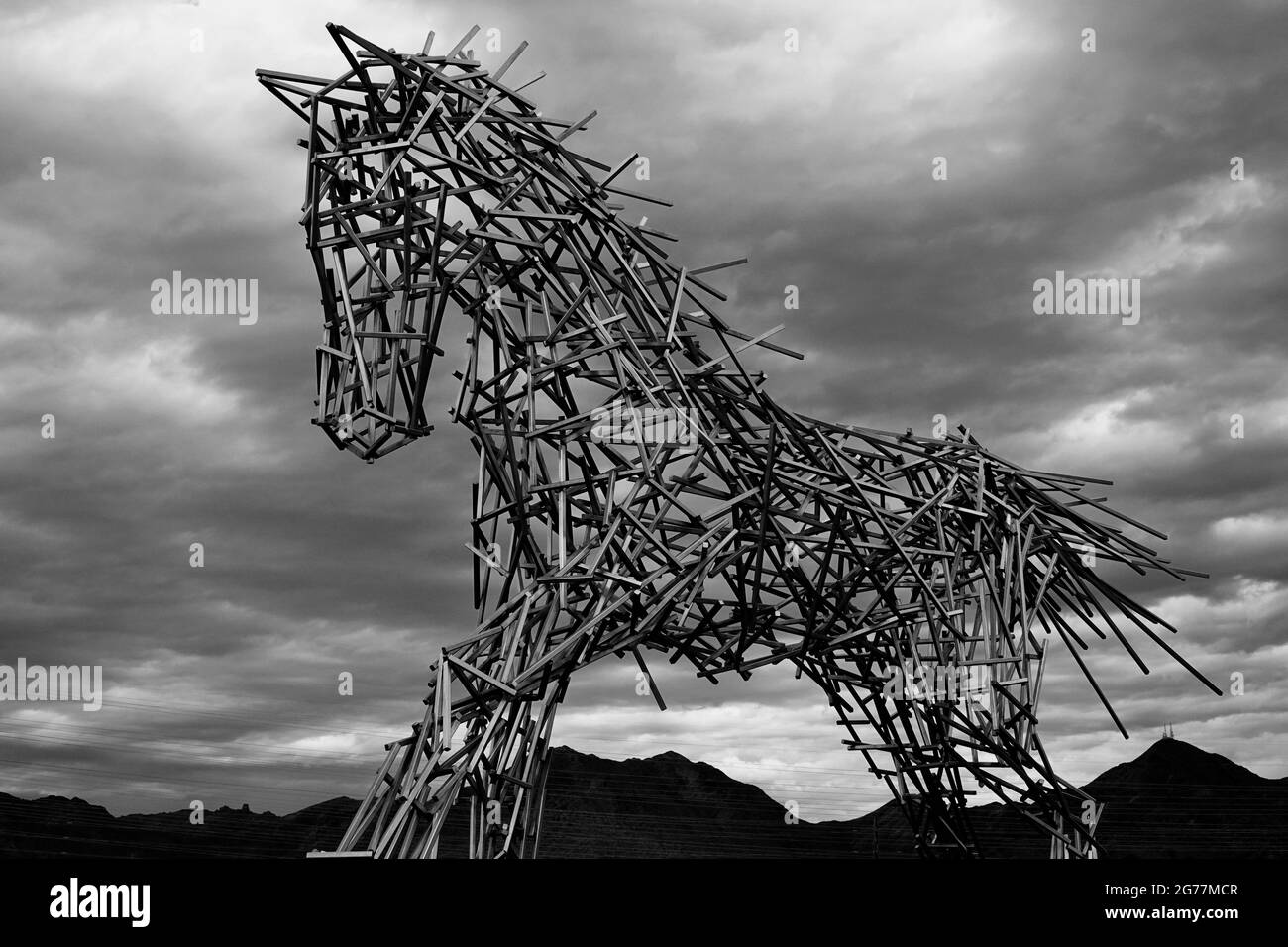A black and white photo of a statue of a steel iron horse on a cloudy day in Scottsdale, Arizona Stock Photo