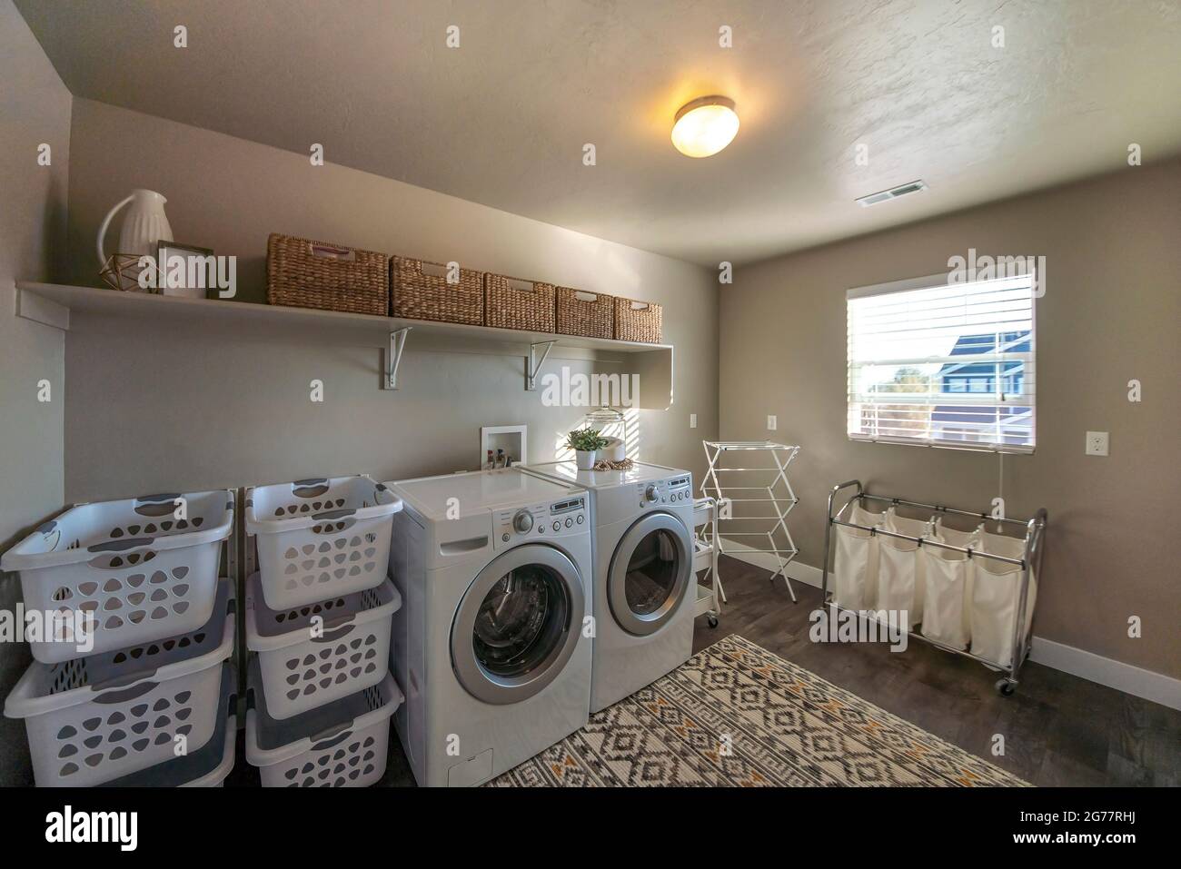 https://c8.alamy.com/comp/2G77RHJ/spacious-laundry-room-with-window-and-lots-of-storage-baskets-2G77RHJ.jpg