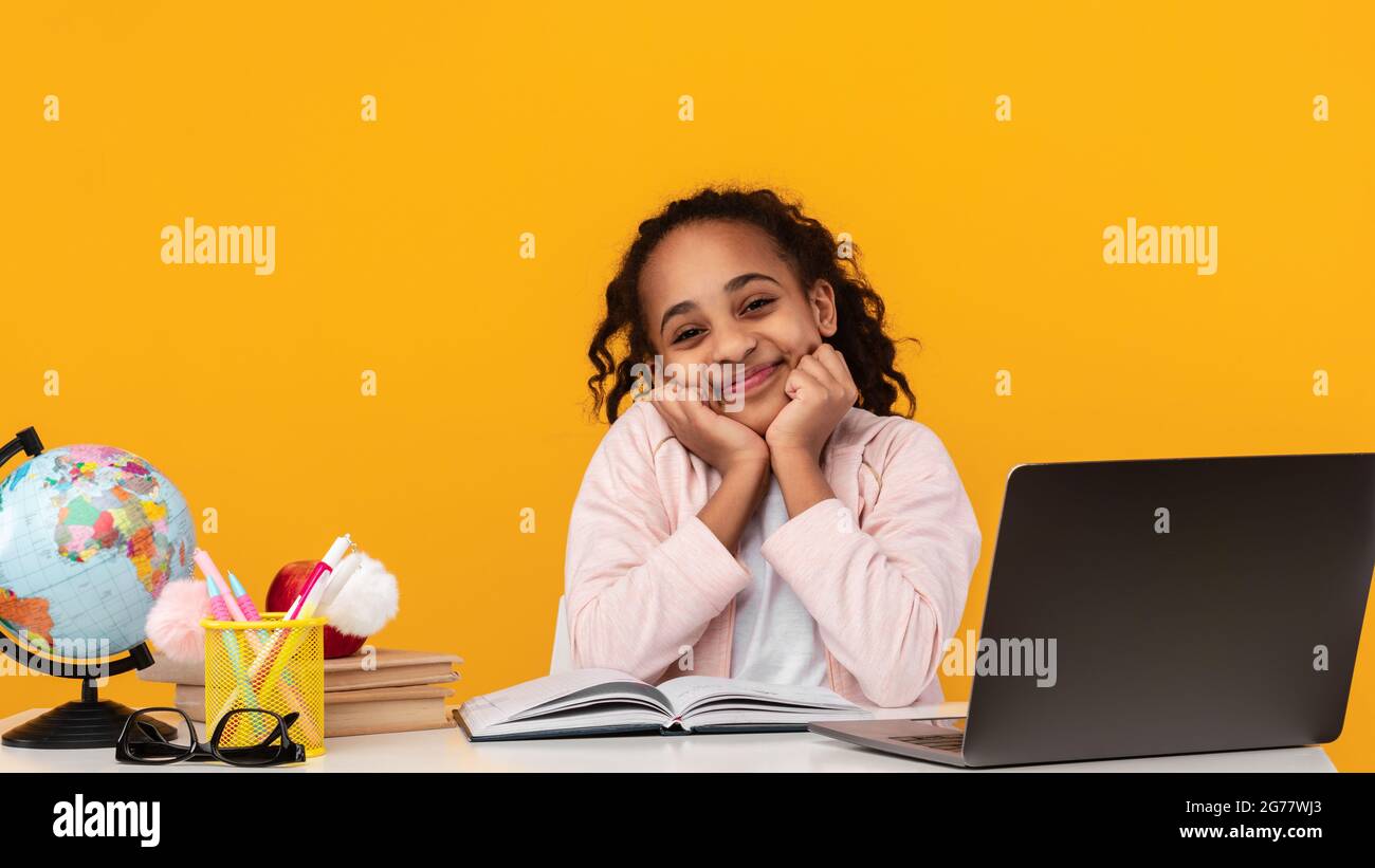Cute Joyful African American Girl Touching Cheeks Sitting At Desk Stock ...