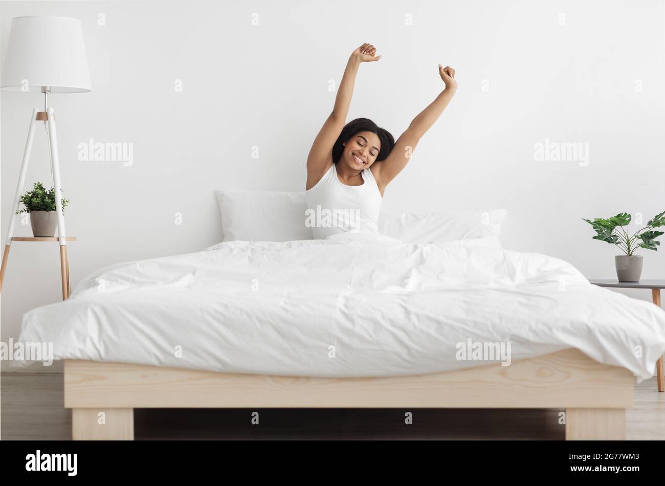 Good start of new day. Wellslept african american lady stretching arms