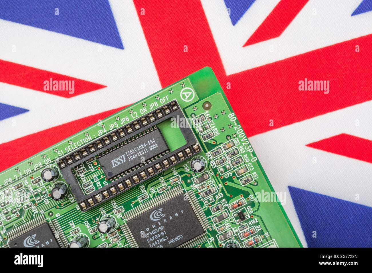 UK Union Jack flag with green PCB circuit board with empty EPROM socket. For 2021 integrated computer chip shortages, semiconductor shortages. Stock Photo
