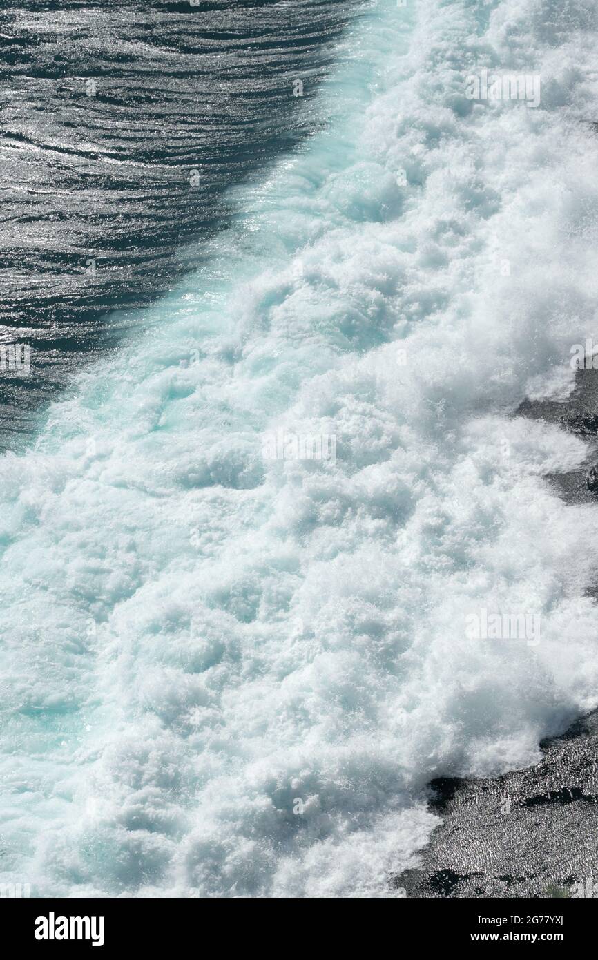 Ocean waves crashing and foaming on rocky shore Stock Photo - Alamy