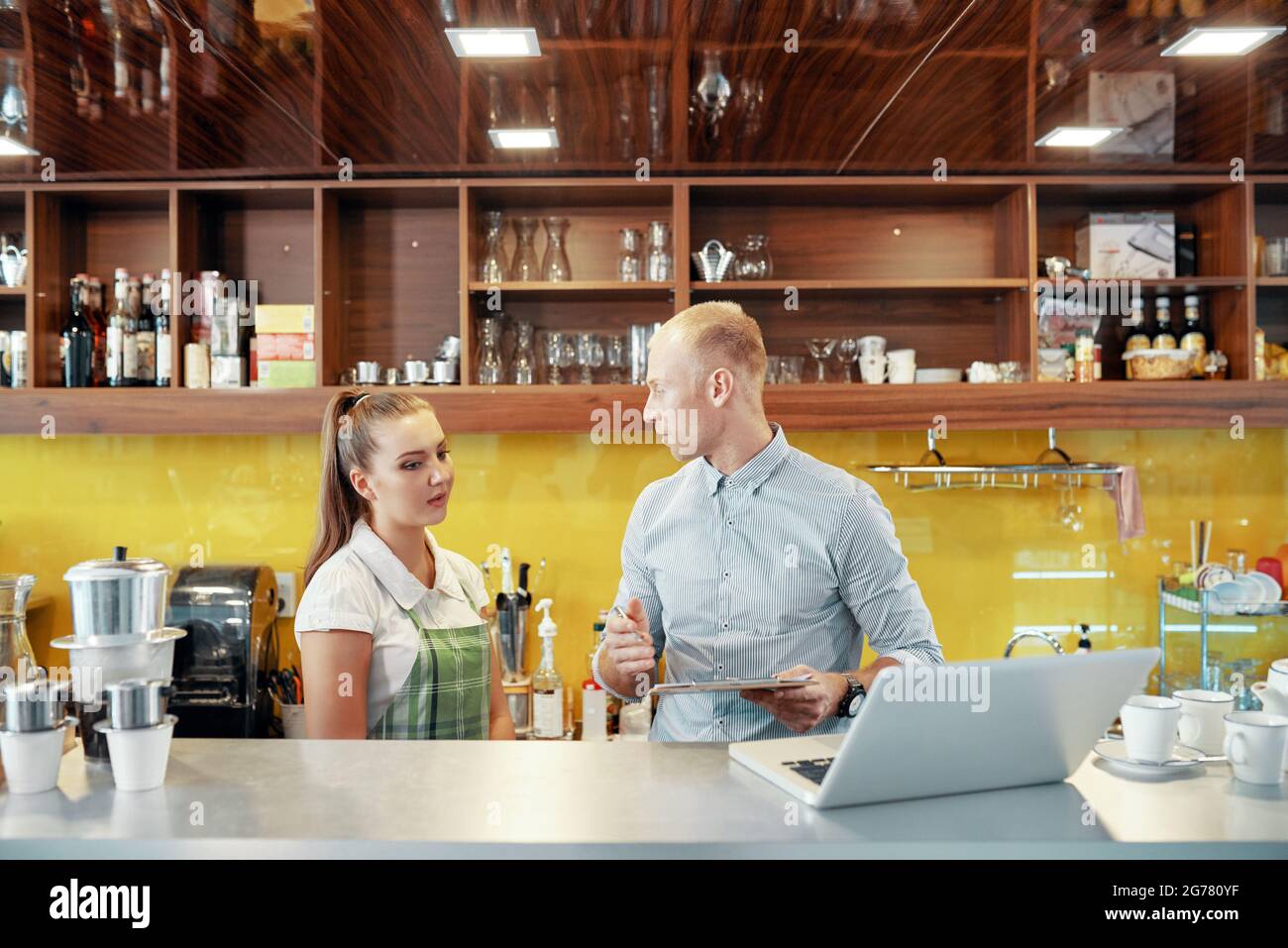 manager explaining work to new barista, he is showing
