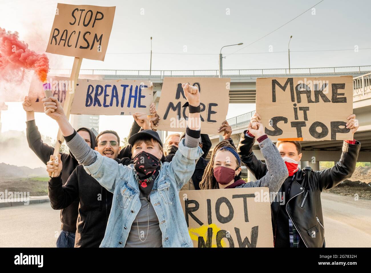 Group of angry young multi-ethnic rebellion people moving with cardboard signs under bridges and fighting for equal rights for all races Stock Photo